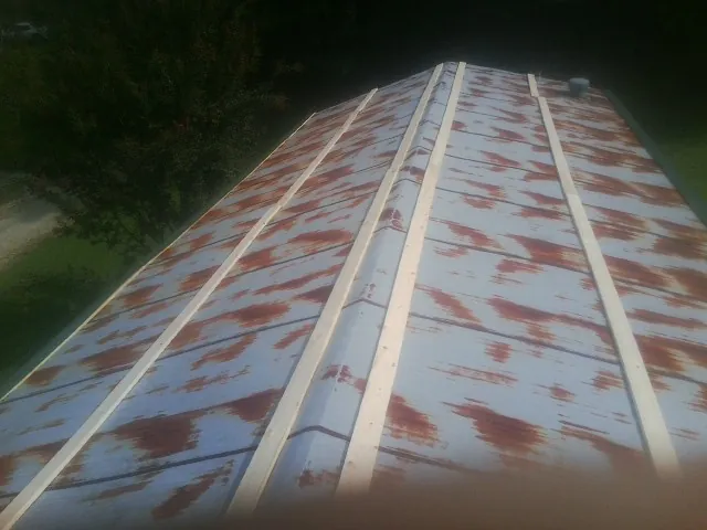 Rusted metal roof panels with new wood purlins before replacement — Storm Damage Roof Repair in Onawa by Roofing Brothers