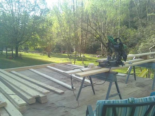 Miter saw and framing lumber on a deck under construction in Onawa