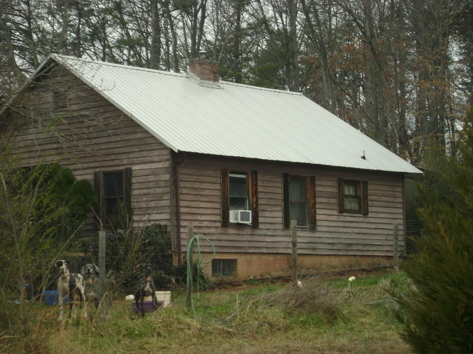 White metal roof on an old wood sided farmhouse, from a Metal Roof Installation job in Onawa